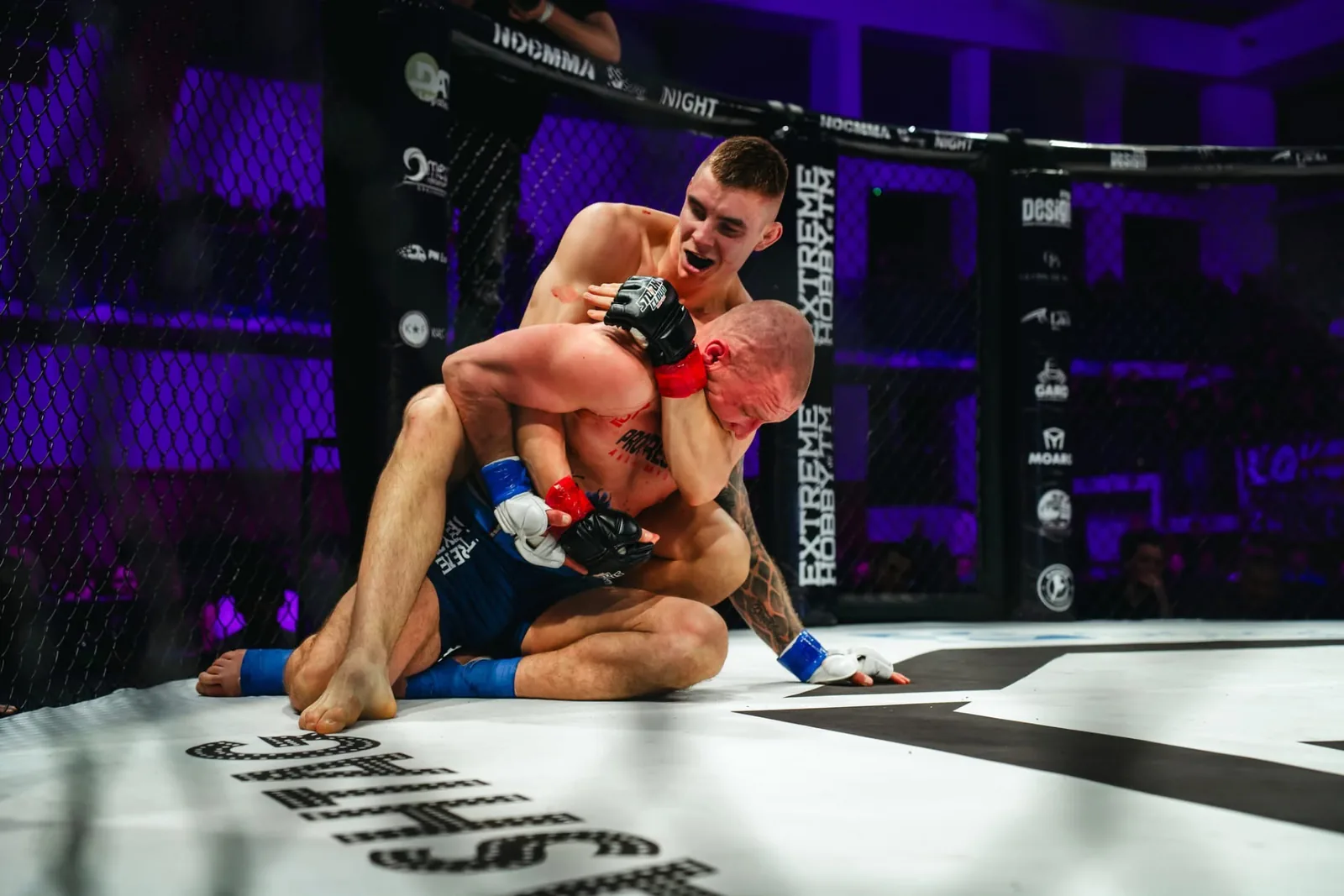 Adam kontroluje rywala w parterze na NOC MMA