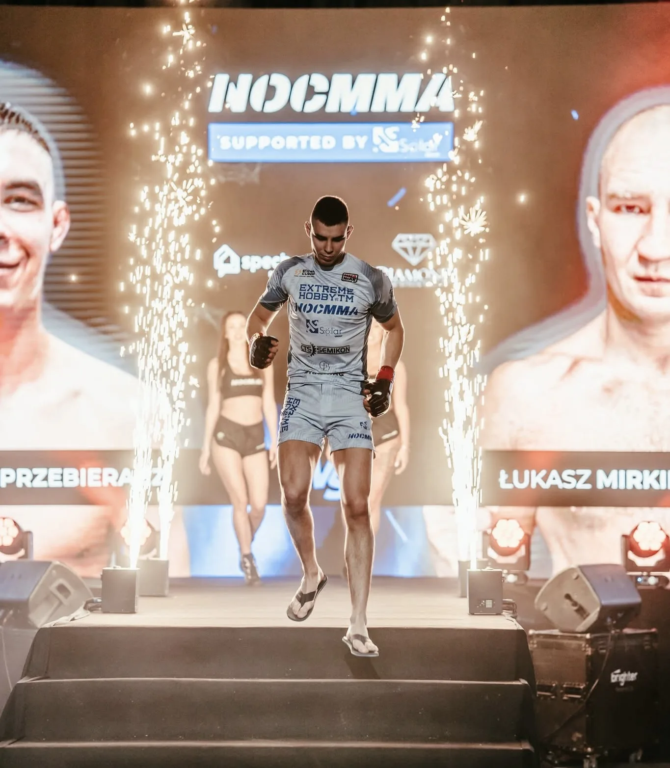 Adam wchodzi do klatki na NOC MMA w blasku pirotechniki